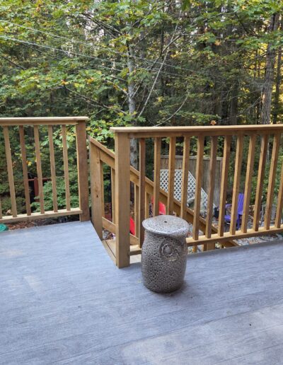 Pressure-treated Sienna deck railings installed by Steve’s Woodworking in Shawnigan Lake, overlooking a wooded backyard.